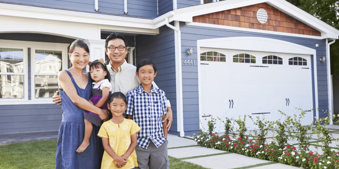 family of five outside of home with garage