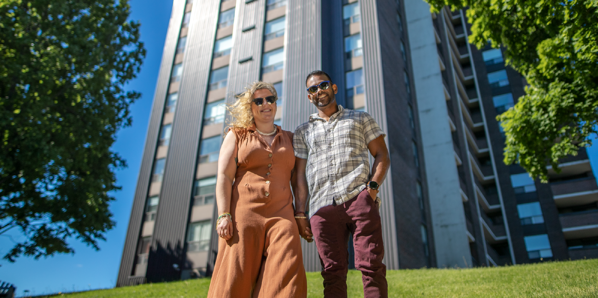 Toronto couple standing in front of condo building - buy and sell homes stress free with Properly
